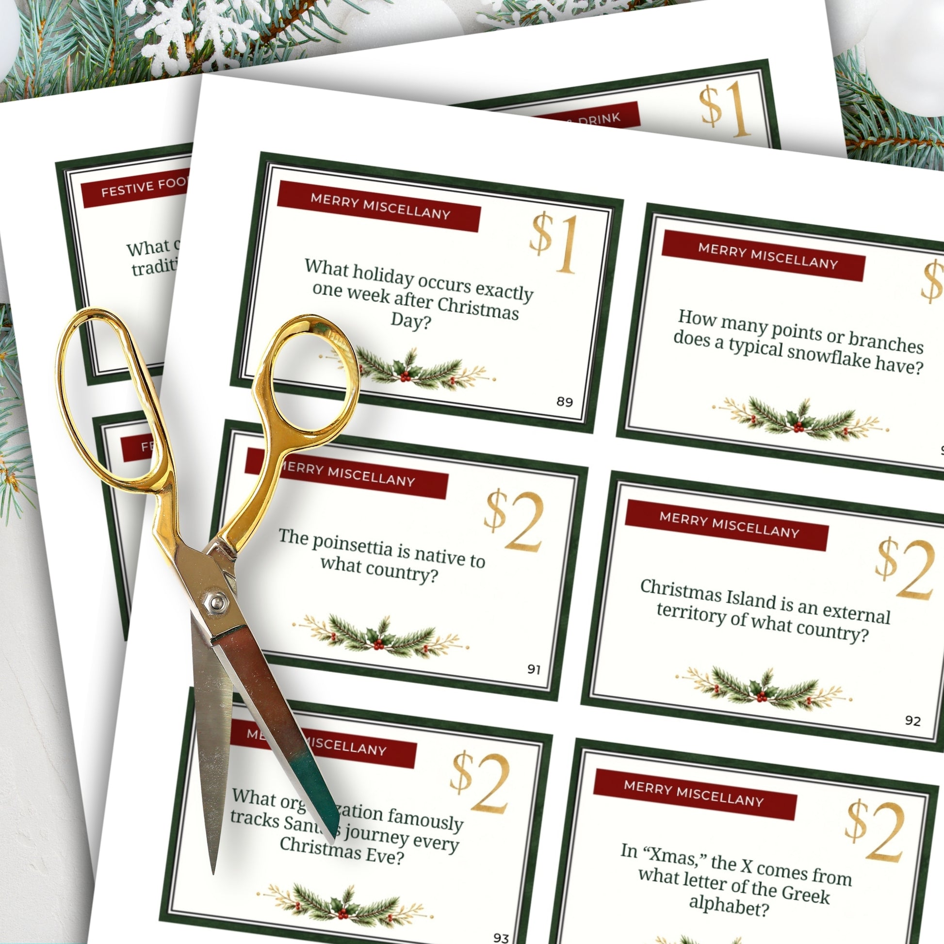 A set of Christmas-themed miscellany trivia cards arranged in a fan shape, with gold-handled scissors resting on top. The cards feature festive red headers, gold and black text, and holiday green borders with pine and holly illustrations.